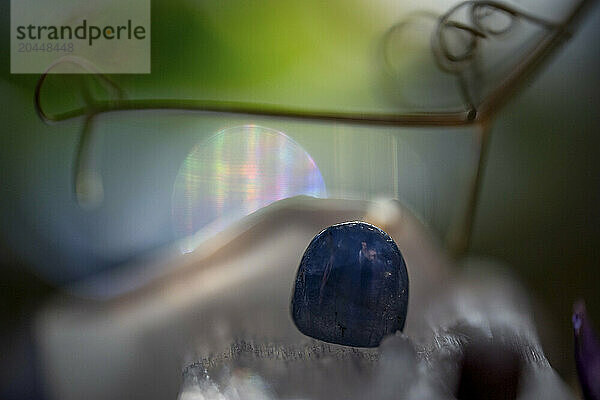 Close-up image of a translucent blue crystal with a bokeh background  highlighting the crystal's texture and varied shades.