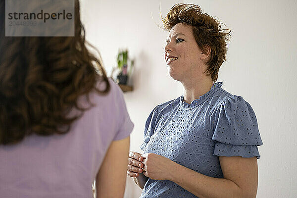 Two women enjoying a conversation indoors