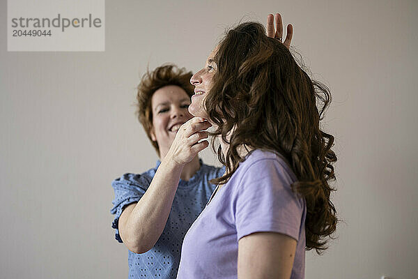 Two women smiling and styling hair