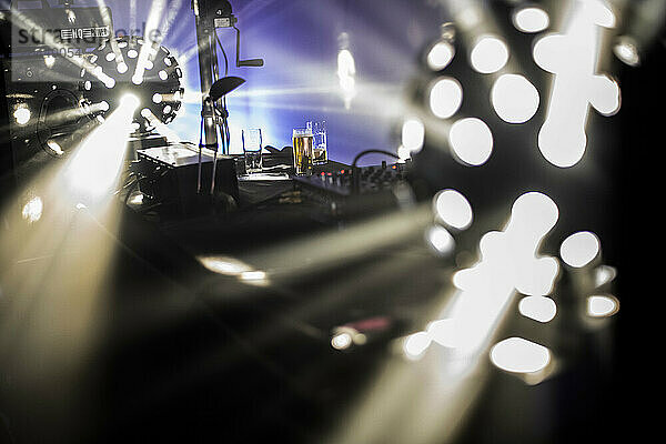 Concert stage with bright lights and musical equipment.