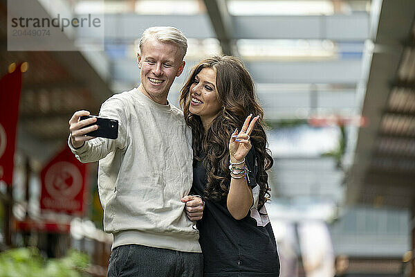 Couple taking a selfie with peace sign gesture