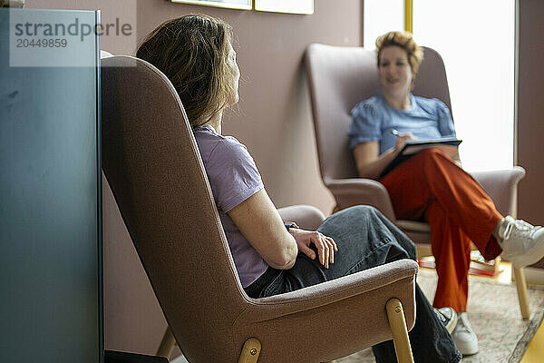 Two people conversing in a cozy room.