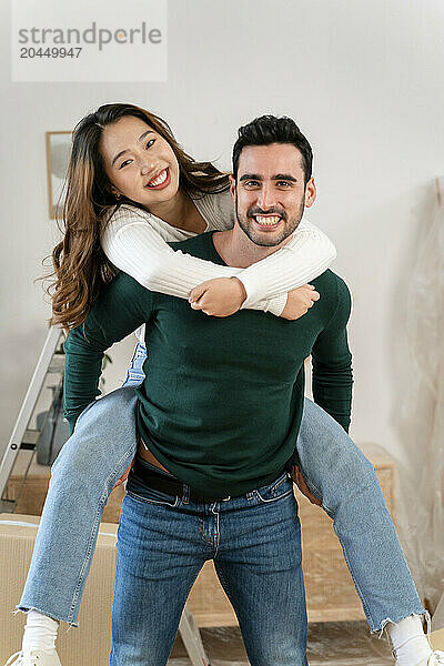 Man giving piggyback ride to woman indoors