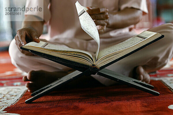 Muslim man sitting reading the Quran (Koran) the holy book of Islam  Mubarak Mosque  Chau Doc  Vietnam  Indochina  Southeast Asia  Asia