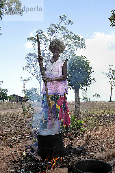 Aboriginal Yolngu elder stirs freshly dyed pandanus fronds to be used for basket making at Nyinyikay Homeland  East Arnhem Land  Northern Territory  Australia  Pacific