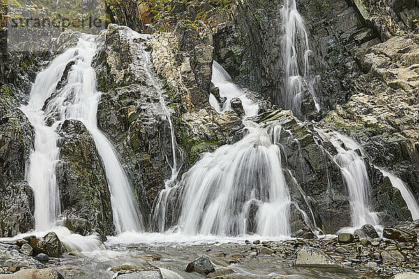 Waterfall pouring down a rocky cliff  with blurred motion  resulting from a slow shutter speed; at Welcombe Mouth  Hartland  north Devon  England  United Kingdom  Europe