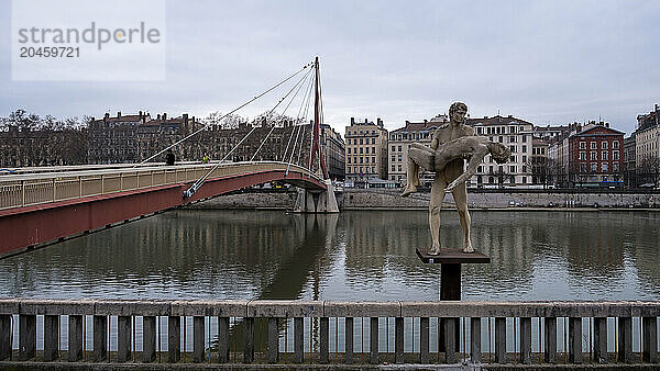 Cityscape of the city of Lyon in France from the riverside of the Saone River with the The Weight of Oneself sculpture in the foreground in front of the courthouse  Lyon  Auvergne Rhone Alpes  France  Europe