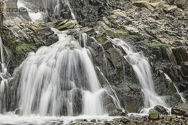 Waterfall pouring down a rocky cliff  with blurred motion  resulting from a slow shutter speed; at Welcombe Mouth  Hartland  north Devon  England  United Kingdom  Europe