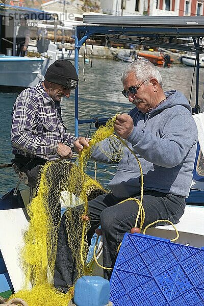 Fishermen mending nets in the harbour of Symi  Symi Island  Dodecanese  Greek Islands  Greece  Europe