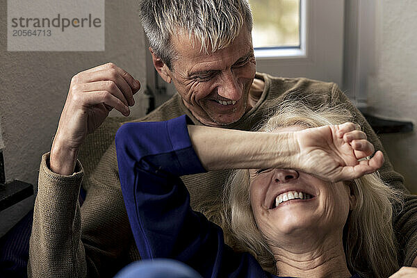 Cheerful retired couple relaxing together at home