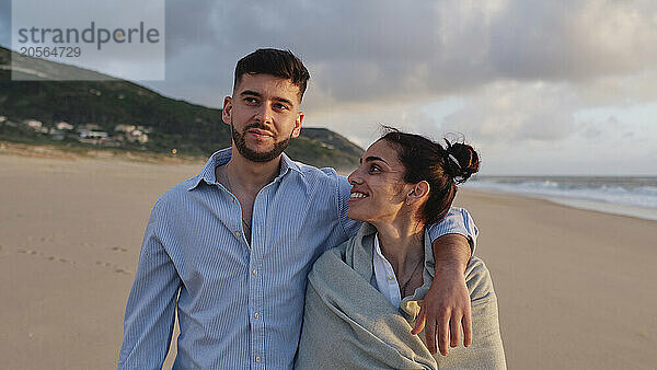 Smiling woman spending leisure time with boyfriend at beach