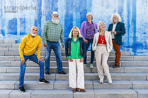 Happy men and women standing on steps