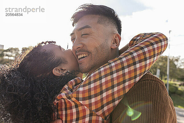 Young woman embracing boyfriend at park