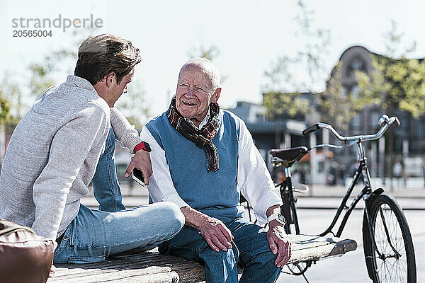 Happy senior man talking to grandson on sunny day