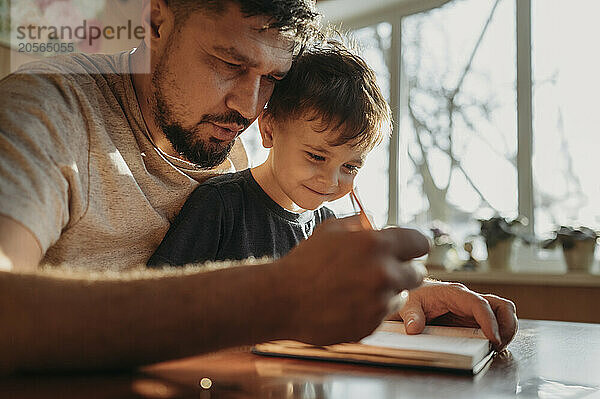 Father helping son with homework at home