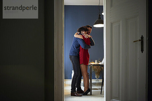 Happy woman embracing boyfriend at home