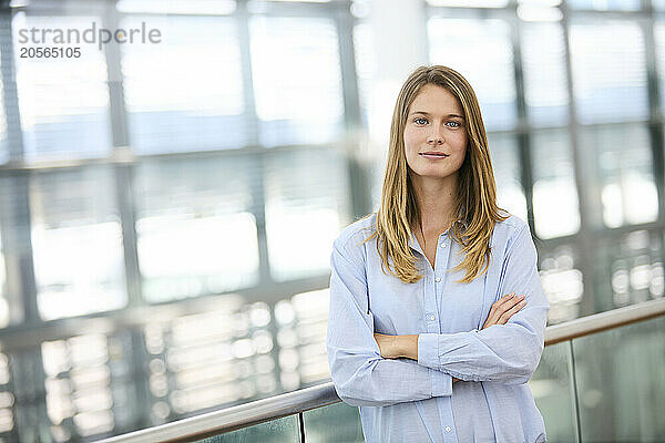 Smiling businesswoman with arms crossed standing at airport