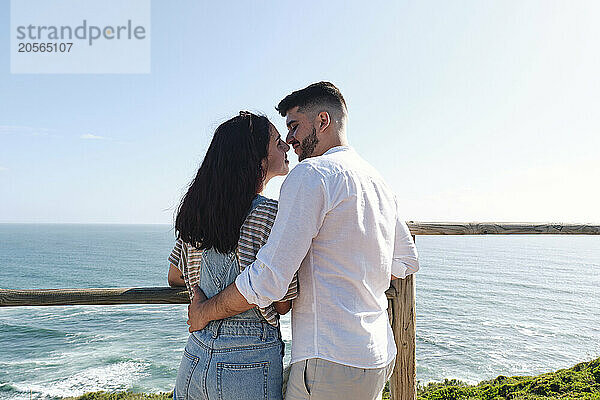 Affectionate young couple standing near railing