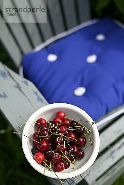 Bowl of cherries kept on chair