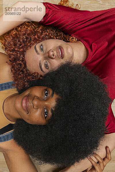 Beautiful multiracial friends lying on floor