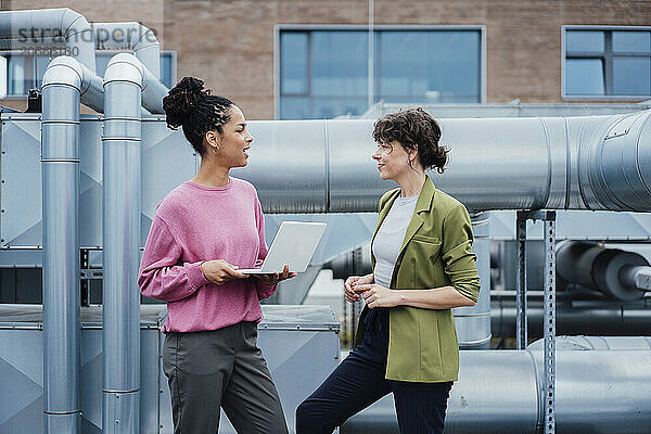 Businesswoman discussing with manager by machinery