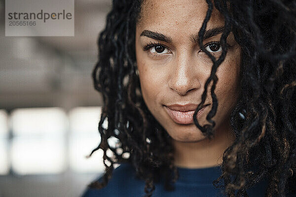 Confident young businesswoman with dreadlocks at office