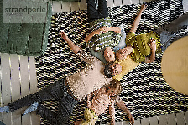 Family lying down together on carpet at home