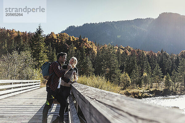 Mature couple leaning on railing at weekend