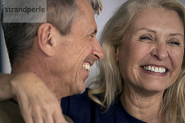 Cheerful senior woman with arm around man