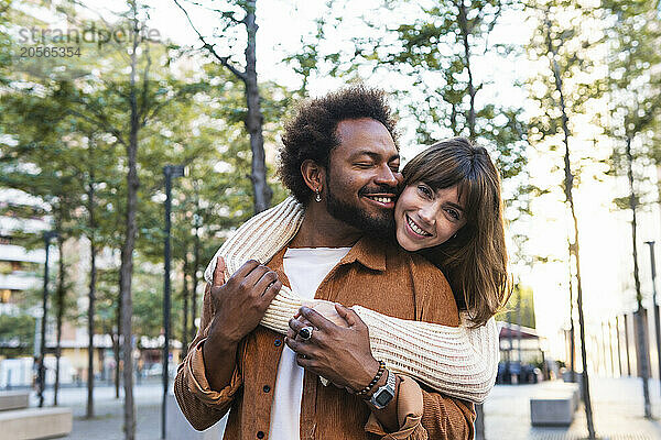 Happy woman with embracing boyfriend from behind