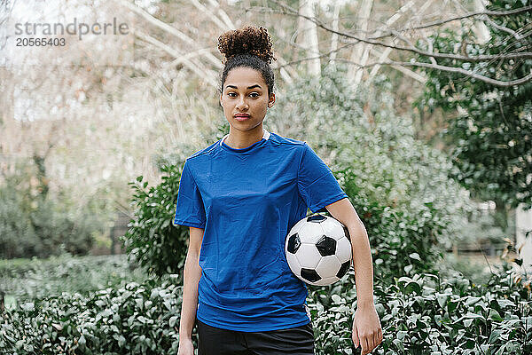 Young woman soccer player with a soccer ball in a park in Barcelona  Spain.