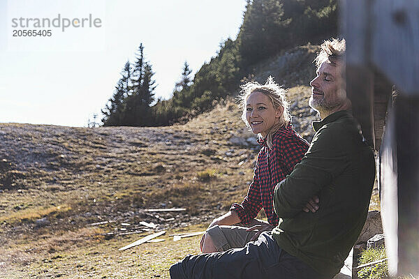 Happy couple sitting on mountain in Tyrol