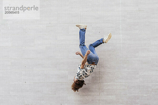 Man doing back flip by wall