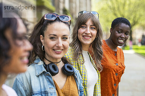 Smiling young woman with multiracial friends