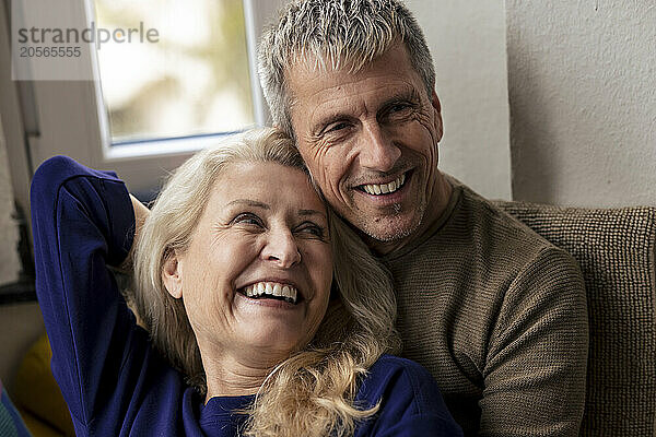 Cheerful retired senior couple relaxing together at home