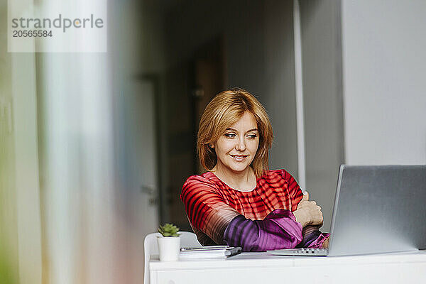 Businesswoman using laptop at home