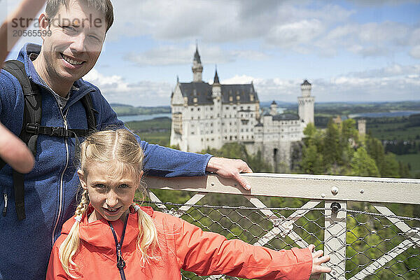 Father with daughter posing in front of a castle