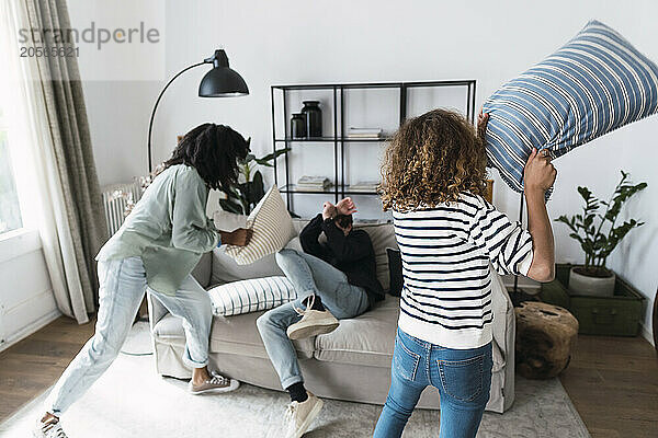 Lively family having fun with a pillow fight at home