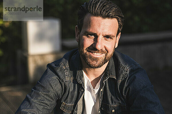 Happy man with beard on sunny day