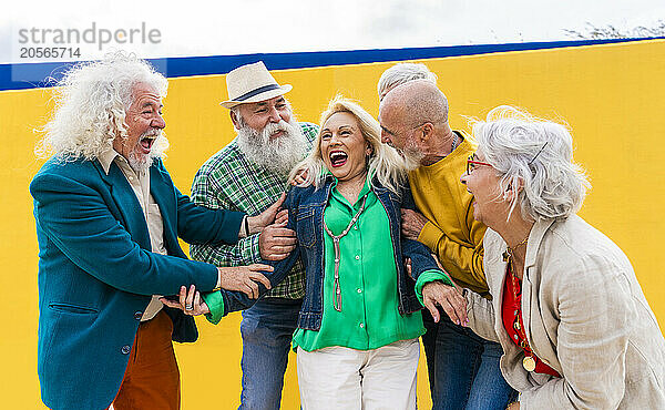 Playful elderly men and women catching friend