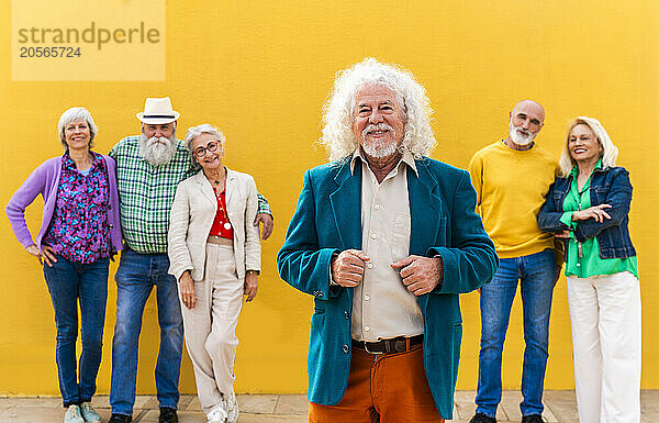 Happy senior man with friends in background