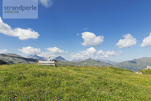 Austria  Salzburger Land  Female hiker relaxing on bench at Stubnerkogel mountain