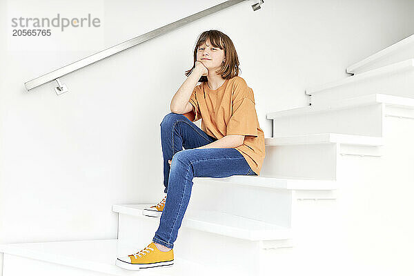 Girl sitting on staircase at home