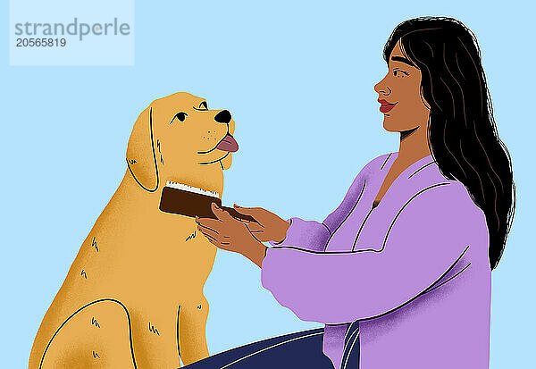 Woman brushing pet dog in front of blue background