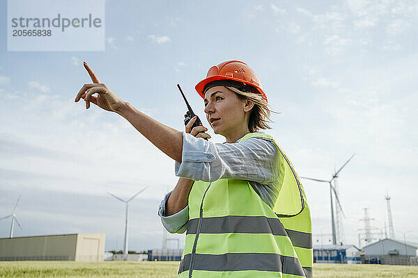 Maintenance engineer talking through walkie-talkie at field