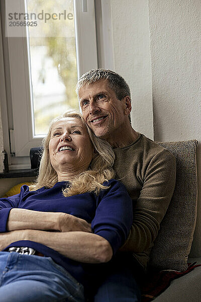 Smiling relaxed senior couple sitting together at home