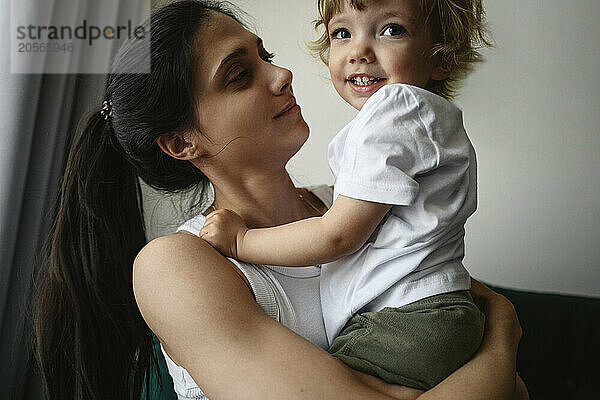 Mother carrying baby boy at home