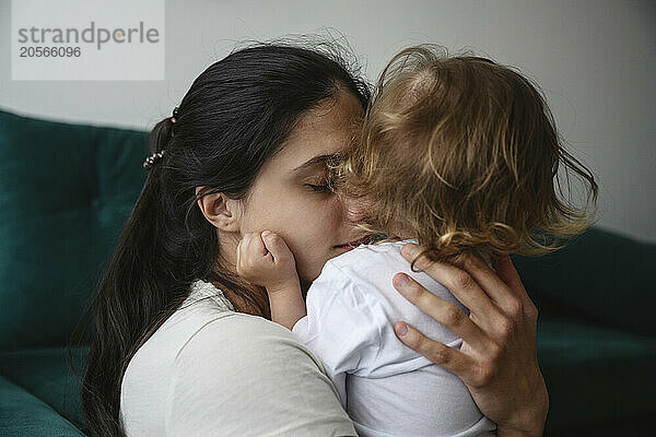 Mother embracing baby boy at home