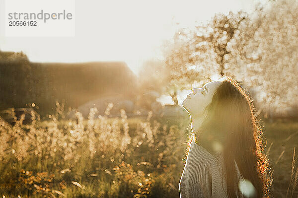 Teenage girl with eyes closed at sunset