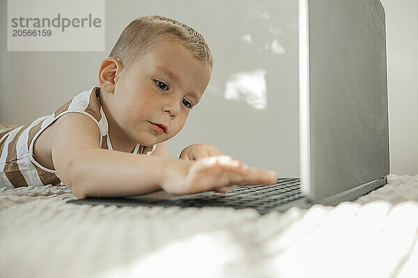 Boy on bed using laptop at home